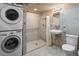 Clean and modern bathroom with a stand-up shower, stacked washer dryer, and sleek fixtures at 1545 August Ln, Brighton, CO 80601