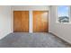 Bright room featuring neutral walls, carpeting, window, and double closets at 1545 August Ln, Brighton, CO 80601