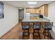Efficient kitchen with wooden cabinets, white appliances, counter seating, and durable floors at 1545 August Ln, Brighton, CO 80601