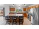 Bright kitchen featuring an island with seating, stainless steel appliances, and wood cabinets at 1545 August Ln, Brighton, CO 80601