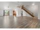 Open-concept living space featuring hardwood floors, vaulted ceilings, and staircase to upper level at 1545 August Ln, Brighton, CO 80601