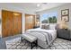 Light-filled main bedroom showcasing closet doors, an area rug, and a cozy bench at 1545 August Ln, Brighton, CO 80601