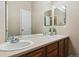 Bathroom with double sinks and wood cabinets at 1430 Milbury St, Castle Rock, CO 80104