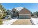 Brick home with two-car garage and snow-covered landscaping at 1430 Milbury St, Castle Rock, CO 80104