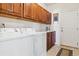 Laundry room with washer, dryer, cabinets, and access to backyard at 1430 Milbury St, Castle Rock, CO 80104