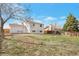 View of the backyard and back of the house featuring a deck, large grassy area, and fencing at 9306 Clermont Dr, Thornton, CO 80229