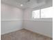 Finished basement featuring neutral paint, carpeting and a large bright window at 9306 Clermont Dr, Thornton, CO 80229