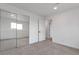 A bedroom featuring neutral carpet, white walls, a window, and closet with mirrored sliding doors at 9306 Clermont Dr, Thornton, CO 80229