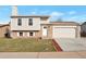 Two-story home featuring an attached garage, well-kept lawn, and a brick facade at 9306 Clermont Dr, Thornton, CO 80229
