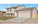 Two-story home featuring an attached garage, well-kept lawn, and a brick facade at 9306 Clermont Dr, Thornton, CO 80229