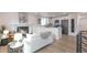 Bright living room featuring a modern fireplace, open to the kitchen with stainless steel appliances and white cabinetry at 9306 Clermont Dr, Thornton, CO 80229