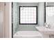Well-lit bathroom with a retro glass block window above the tub and a pedestal sink at 1010 N Jasmine St, Denver, CO 80220