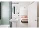 Stylish bathroom with mint tile, pedestal sink, and a glimpse into the connected bedroom at 1010 N Jasmine St, Denver, CO 80220
