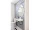 Chic powder room with blue patterned wallpaper, a sleek sink, and black and white tile floor at 1010 N Jasmine St, Denver, CO 80220