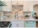 Well-lit kitchen showcasing a retro range, stylish backsplash, white cabinets, and modern fixtures for cooking and entertaining at 1010 N Jasmine St, Denver, CO 80220