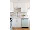 Modern kitchen with sleek white cabinetry, tiled backsplash, and vintage-inspired dishwasher at 1010 N Jasmine St, Denver, CO 80220