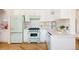 Charming kitchen features retro appliances, white cabinets, and herringbone floors at 1010 N Jasmine St, Denver, CO 80220