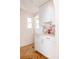 Well-lit laundry area featuring white cabinetry, quartz counters, and a charming pink-themed tile backsplash at 1010 N Jasmine St, Denver, CO 80220