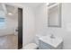 Cozy bathroom featuring modern vanity, mirror, and adjacent kitchen with an open layout at 4636 Leaf Ct, Denver, CO 80216