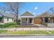 Street view showcasing the cute beige exterior, a small covered porch, and grassy yard at 4636 Leaf Ct, Denver, CO 80216