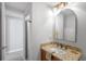 Bathroom featuring granite countertop, a decorative mirror, and a walk-in shower at 3206 S Clayton St, Denver, CO 80210
