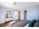 Bright bedroom features hardwood floors, an accent wall, and an adjacent closet at 3206 S Clayton St, Denver, CO 80210