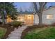 Charming single-story home featuring a brick facade, a welcoming front porch, and mature trees in the landscaped yard at 3206 S Clayton St, Denver, CO 80210