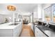 Bright kitchen open to the dining area, with white cabinets and stainless-steel appliances at 3206 S Clayton St, Denver, CO 80210