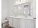 A well lit bathroom featuring a double sink vanity, an expansive mirror, and a separate toilet area for added convenience at 24719 E 39Th Ave, Aurora, CO 80019