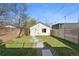 Backyard with manicured lawn, stone pathway, mature tree, wood fencing and detached dwelling at 3938 Kalamath St, Denver, CO 80211