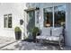 Cozy front entrance with a bench, black planters, and clear door with visible house number at 3938 Kalamath St, Denver, CO 80211
