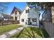 Inviting two-story home with a white exterior, green lawn and a seating area in the front at 3938 Kalamath St, Denver, CO 80211