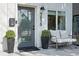 Inviting front porch with seating, potted plants, and a stylish gray front door at 3938 Kalamath St, Denver, CO 80211