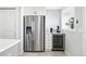 Modern kitchen featuring stainless steel refrigerator, wine cooler, and custom cabinets for storage at 3938 Kalamath St, Denver, CO 80211