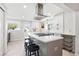Modern kitchen boasts stainless steel appliances, light gray island with bar seating, and white cabinets at 3938 Kalamath St, Denver, CO 80211