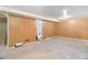 Basement with light wood paneling, carpet, and a doorway leading to another room, offering flexible living space at 3790 W 54Th Ave, Denver, CO 80221