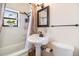 Cozy bathroom featuring a pedestal sink, bathtub, and decorative mirror creating a welcoming and functional space at 3790 W 54Th Ave, Denver, CO 80221