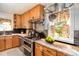 Traditional kitchen with wood cabinets, stainless steel appliances, and tile backsplash at 3790 W 54Th Ave, Denver, CO 80221