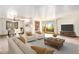 Bright living room with a wooden coffee table, two armchairs, and a tan sofa with a view of the outdoors at 3790 W 54Th Ave, Denver, CO 80221