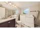 Bright bathroom and laundry area featuring a vanity with sink and modern washer and dryer at 5241 E 111 Th Ct, Thornton, CO 80233