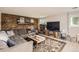 Comfortable living room with brick accent wall, decorative rug, and a rustic wooden coffee table at 5241 E 111Th Ct, Thornton, CO 80233