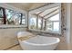 Luxurious bathroom featuring a soaking tub with a scenic view from the large window at 1692 Sand Lily Dr, Golden, CO 80401