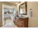 Bright bathroom boasts a wood vanity, granite countertop, soaking tub, and expansive window with views at 1692 Sand Lily Dr, Golden, CO 80401