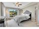 Neutral bedroom with a large window showcasing a forest landscape and light gray bedding at 1692 Sand Lily Dr, Golden, CO 80401