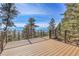 Wood deck and metal railing showcase the picturesque mountain views and blue skies at 1692 Sand Lily Dr, Golden, CO 80401