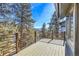 Deck with wood flooring and metal railings overlooks the gorgeous pine trees and mountain views at 1692 Sand Lily Dr, Golden, CO 80401