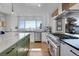 Bright, white kitchen with stainless steel appliances, island, and lovely mountain views at 1692 Sand Lily Dr, Golden, CO 80401