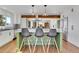 Bright kitchen with a green island, bar stools, and modern stainless steel appliances at 1692 Sand Lily Dr, Golden, CO 80401