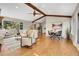 Open-concept living room with hardwood floors, wood beam, and views to the connected kitchen at 1692 Sand Lily Dr, Golden, CO 80401