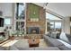 Bright living room with stone fireplace, cathedral ceilings, hardwood floors, and floor-to-ceiling windows at 1692 Sand Lily Dr, Golden, CO 80401